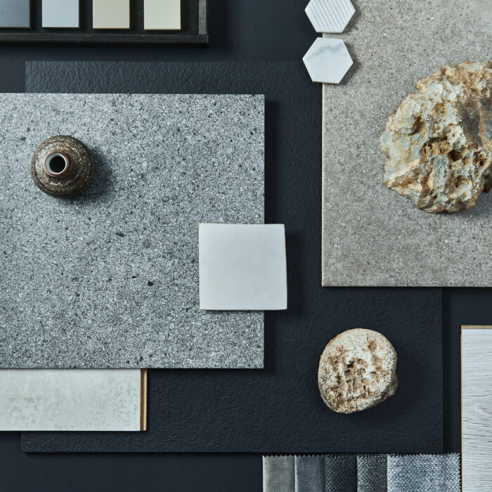 Flat lay composition of creative black architect moodboard with samples of building, textile and natural materials and personal accessories. Top view, black backgroung, template.