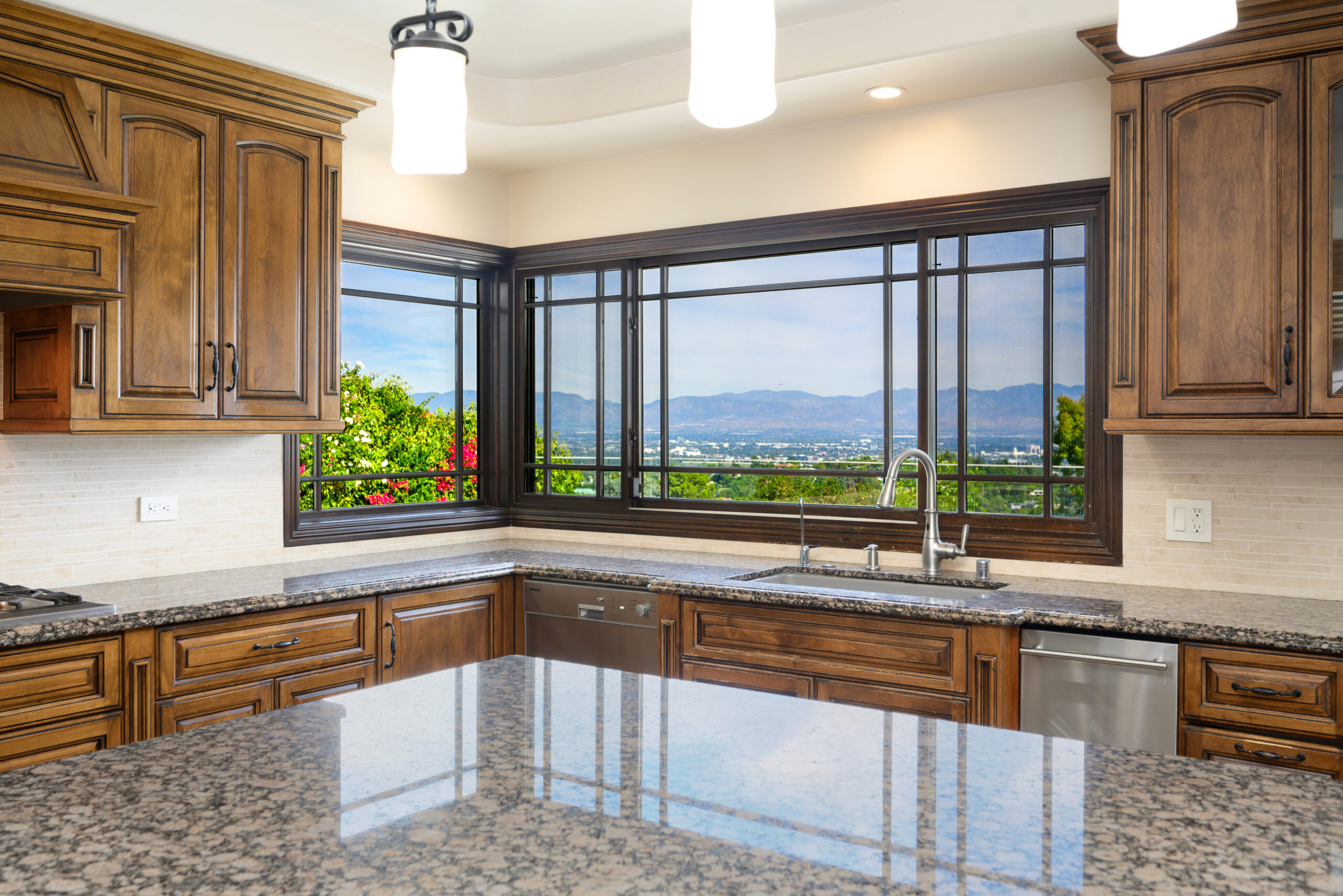 A kitchen island with granite countertops and counters in modern kitchen in Encino, California