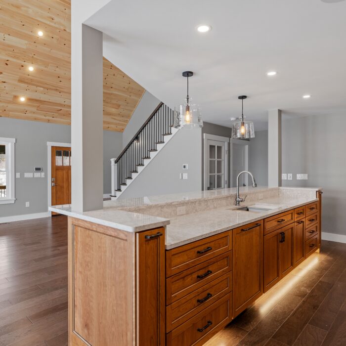 A modern kitchen featuring hardwood floors and stylish furniture